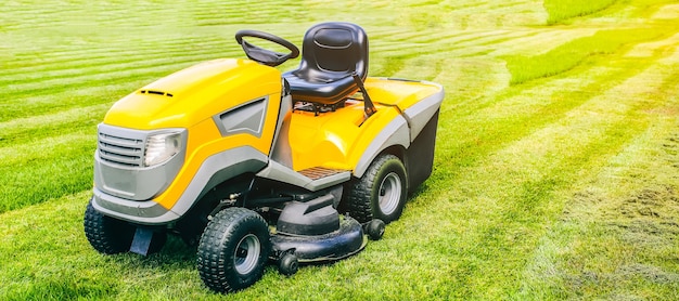 Grass cutter in the work.  Machine for cutting lawn is standing outdoors. Summer bright photo.