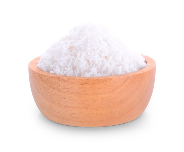 Grated coconut in a wooden bowl on white.