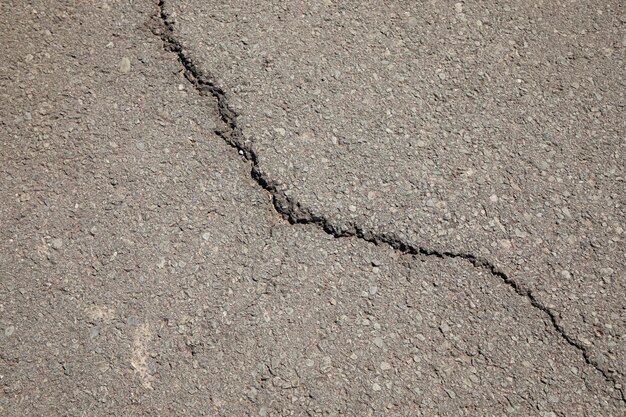 Gray asphalt background and texture with a crack in the center