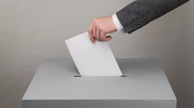 Gray ballot box. Presidential and parliamentary elections. The voter throws the ballot into the ballot box.