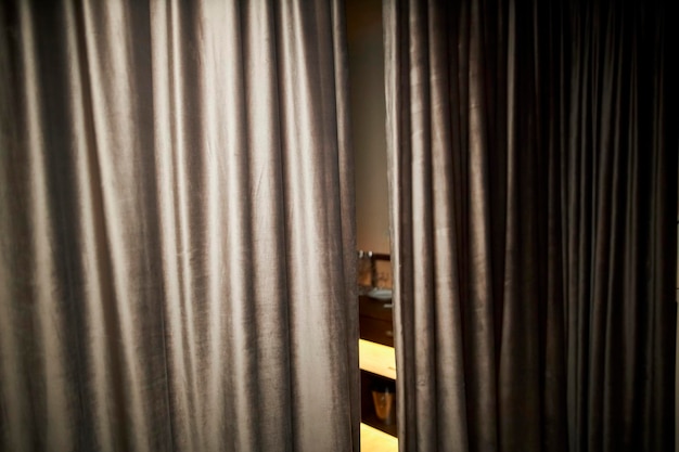 gray blackout curtains in a restaurant covering the banquet hall. olds of symmetrical gray curtains