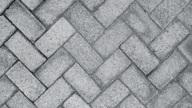 A gray brick sidewalk with a pattern of bricks.