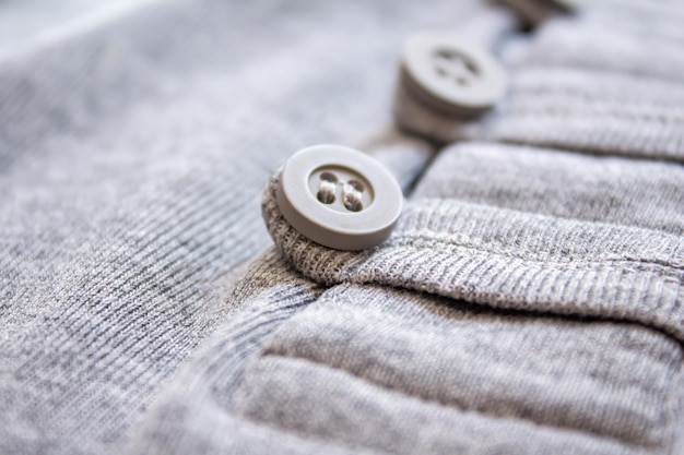 Gray button on the t-shirt. Close up photo of cloth button.