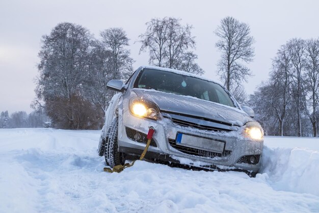 A gray car crashed on a slippery and snowy road on a winter day.