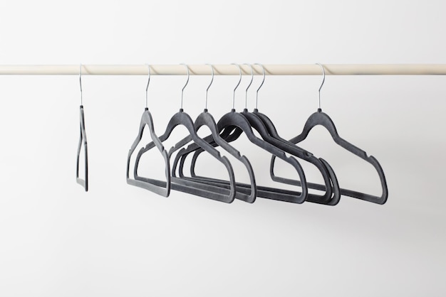 Gray empty hangers on railing white background