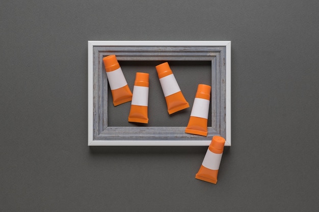 Photo gray frame on a gray background and orange tubes. trendly.