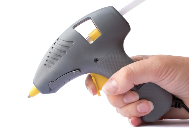 Gray glue gun in a woman hand isolated on white background