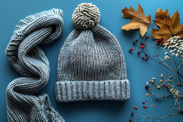 Photo a gray knitted hat with a bobble on a blue background shown from a top view laid flat in style a