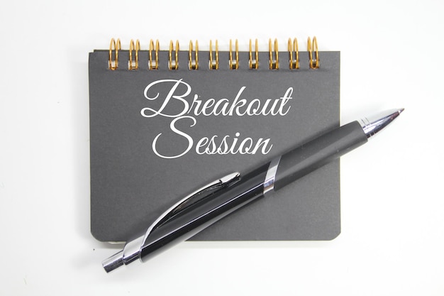 A gray notebook with a pen and a pen that says " break session " on it.