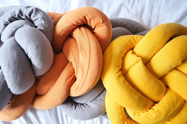 Gray orange and yellow color pillow on bed