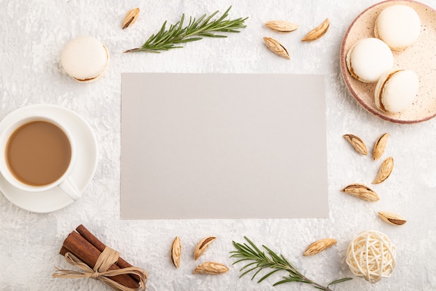 Gray paper sheet with cup of coffee, almonds and macaroons 