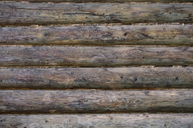 Photo gray round log wall with linen gasket between beams