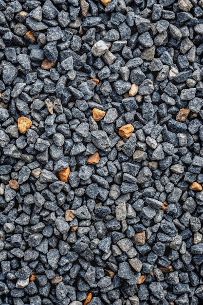 Gray small rocks ground texture black small road stone background gravel pebbles stone seamless texture dark background of crushed granite gravel close up clumping clay