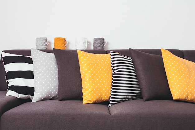 Gray sofa with many colorful pillows on it