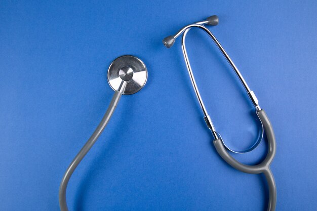 Gray stethoscope on blue surface