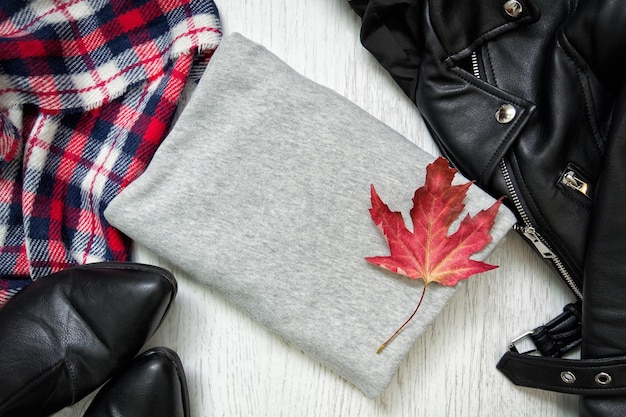 Gray sweater and maple leaf Black jacket checkered scarf and boots Fashionable concept