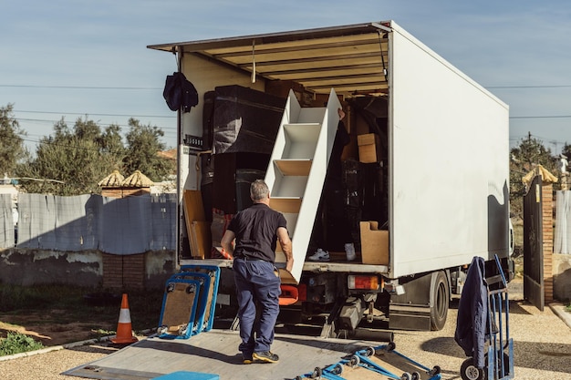 Grayhaired man loading furniture onto a moving truck