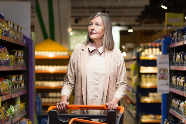 A grayhaired pensioner in a grocery store chooses groceries