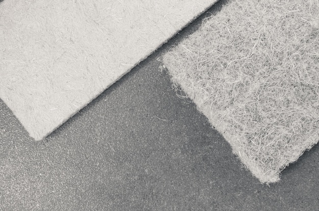 Grayscale shot of compressed thermal insulating hemp fiber panels on a rough-textured surface