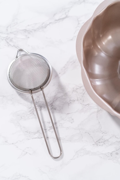 Greasing bunt cake pan to bake chocolate pumpkin bundt cake with toffee glaze.