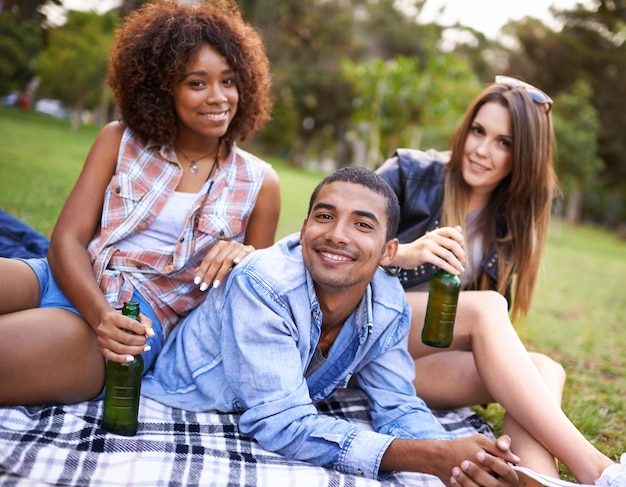 Great day for a picnic in the park Portrait of a group of happy young friends having drinks while on a picnic