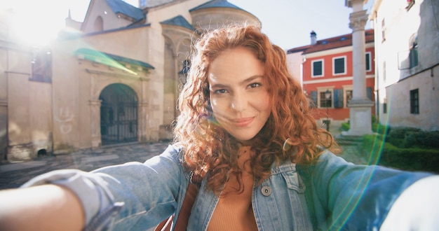 Great emotions portrait view of the caucasian ginger woman holding camera and calling to somebody wh...