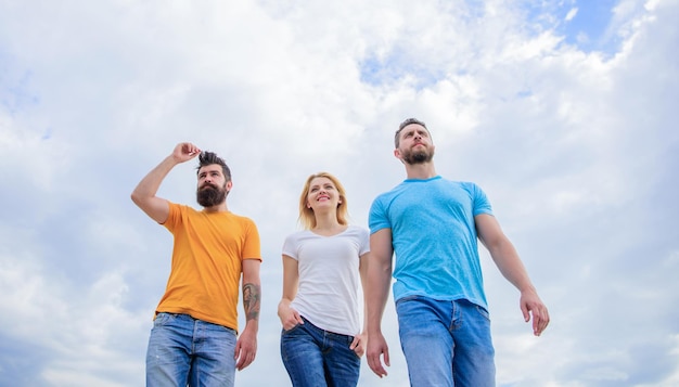 The great fit for the day off Young people in casual style on cloudy sky Group of people in casual wear Fashion people look casual in summer outfit Pretty woman and men friends walking outdoor