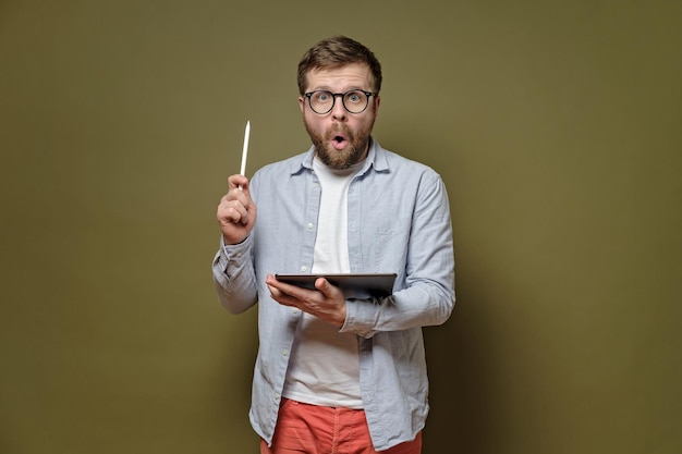 Great idea Caucasian bearded man with glasses indicates stylus pen up holds the tablet in hands