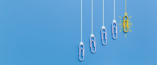 Great ideas concept with paperclip thinking creativity light bulb on blue background