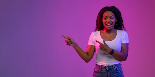 Great Offer Cheerful Black Female Pointing At Copy Space Over Purple Background