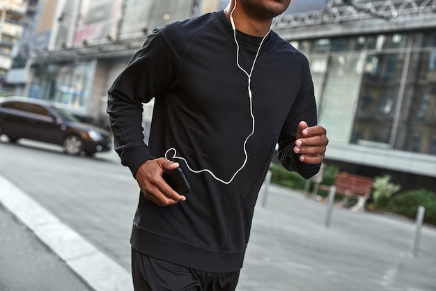 Great song for exercising closeup portrait of athletic african man in stylish sportswear running