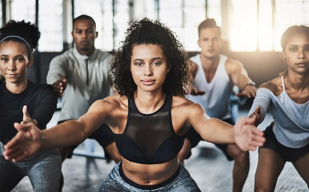 Great things happen when you clear your mind of cant Shot of a group of young people doing squats together during their workout in a gym