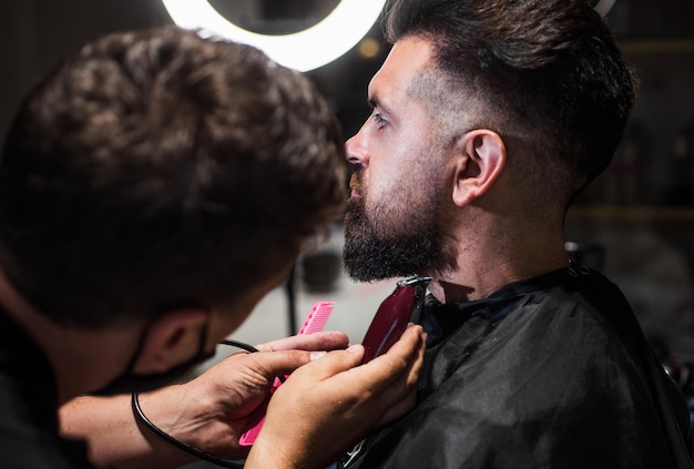 Great time at barbershop barber master cut hair mature hipster with beard at hairdresser brutal hipster making new hairstyle barbershop male trendy hairdo perfect haircut with blade razor