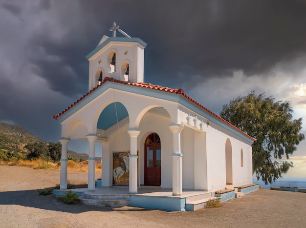 Greek Church St. George Victorious on Greek island Evia in Greece against background of clouds