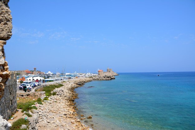 greek coastline with boats and windmills and blue sea and sky