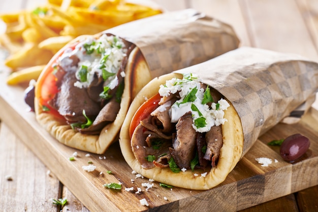 Greek lamb meat gyros with tzatziki sauce, feta cheese and french fries