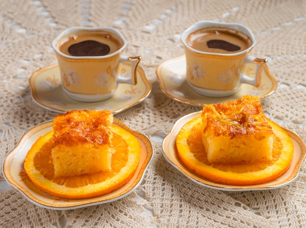 Greek orange pie with orange slices and coffee on a handmade knitted tablecloth in Greece