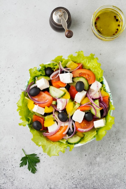 Greek salad in  ceramic plate on gray concrete