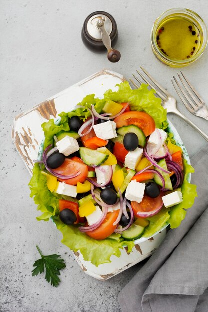 Greek salad in  ceramic plate on gray concrete