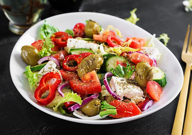 Greek salad of fresh  tomato, sweet pepper, cucumber, red onion, feta cheese and green olives. Healthy vegetarian food.