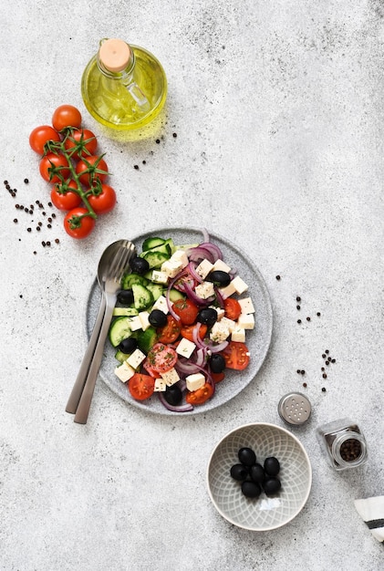 Greek salad with feta cheese olives and olive oil on a stone background Appetizer with cheese