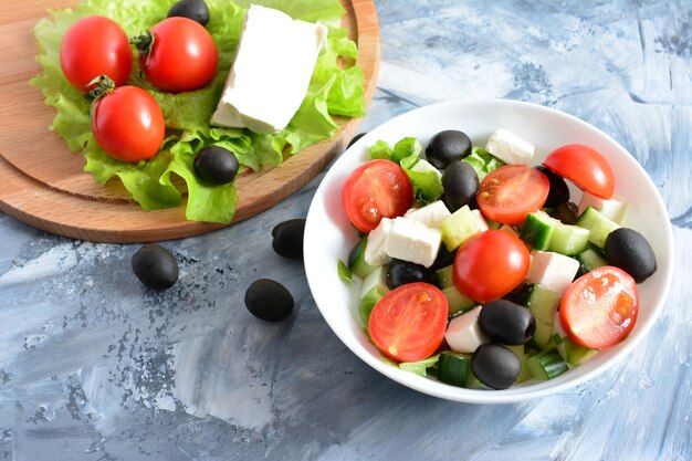 greek salad with tomatoes cucumbers olives feta on the concrete background