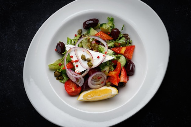 Greek salad with vegetables and cheese on a dark background