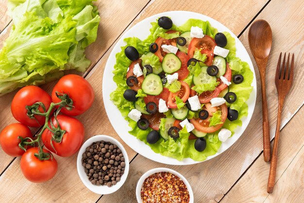 Greek salad. On a wooden background with tomatoes, cucumbers and feta cheese.