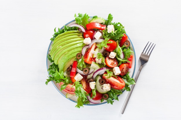 Greek style avocado tomato salad with feta cheese, olives, cucumber, onion, lettuce