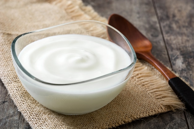 Greek yogurt in glass bowl on wooden table