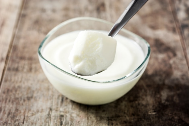 Greek yogurt in glass bowl on wooden table