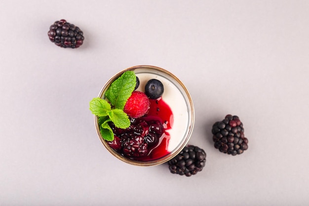 Greek yogurt with berries jam and mint in ceramic cup high quality photo