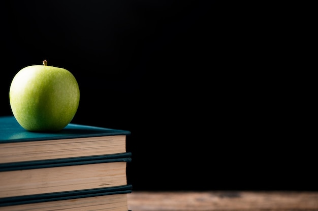 Green apple on books to a school centre. Back to school Concept