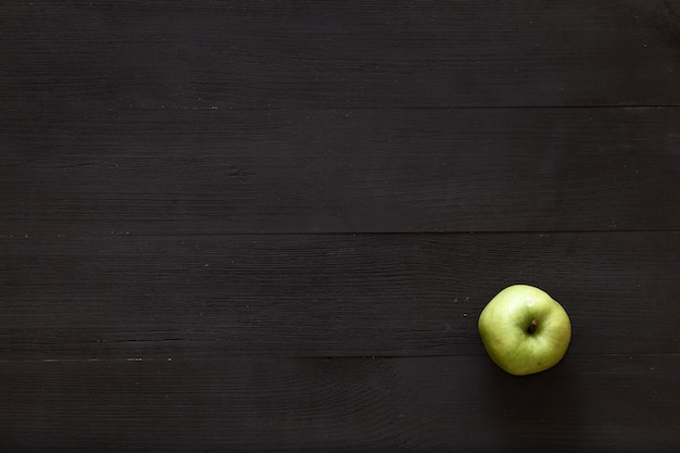 A green apple on brown wooden background